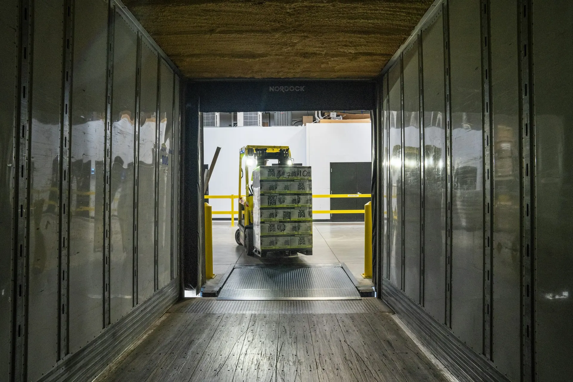 Forklift loading pallets of goods at a loading dock